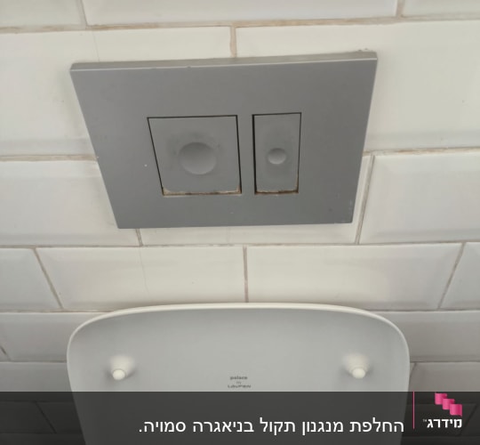 לחצן הדחה על קיר אריחים לבנים